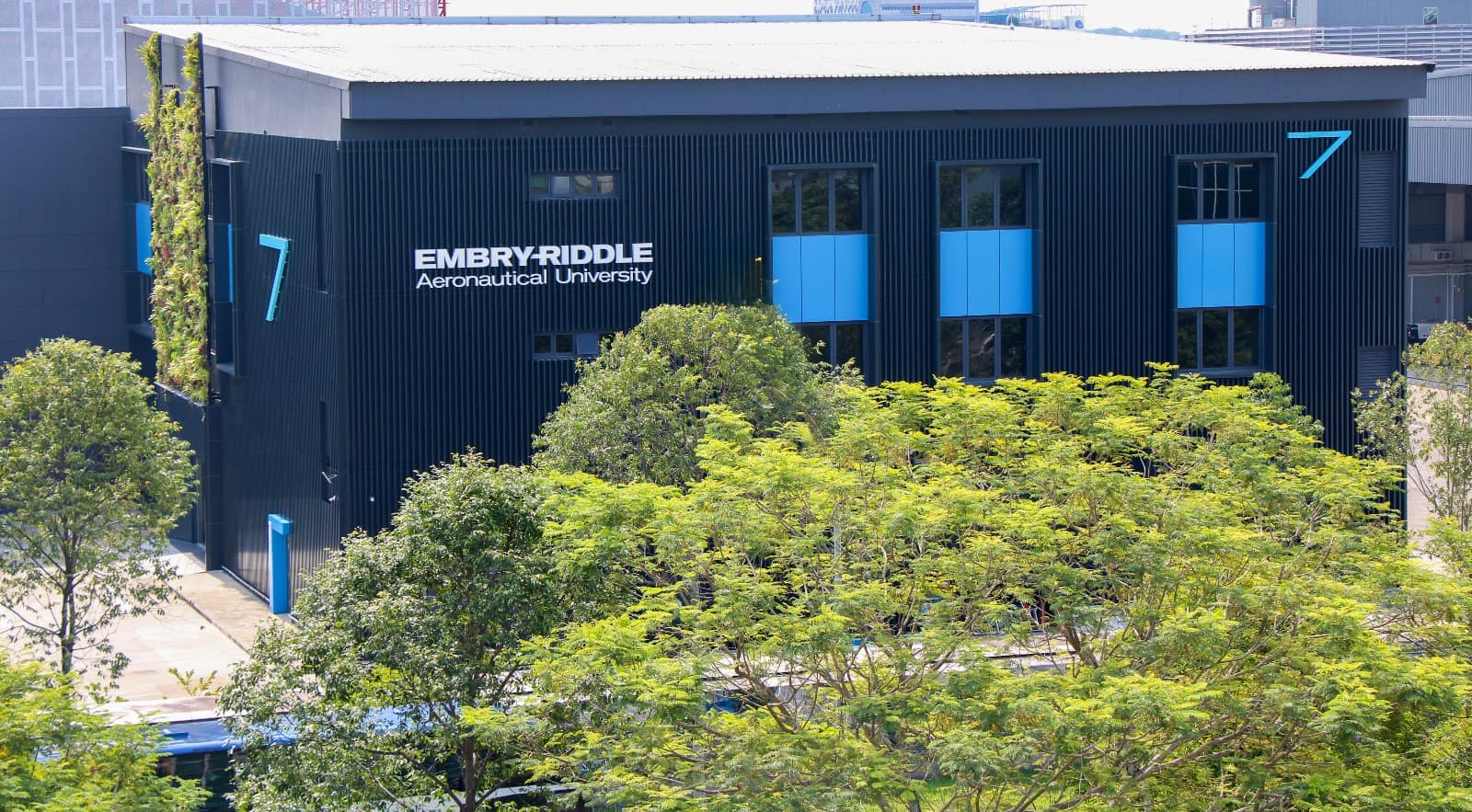 An side view of a blue building which says Embry-Riddle Aeronautical University on the side.